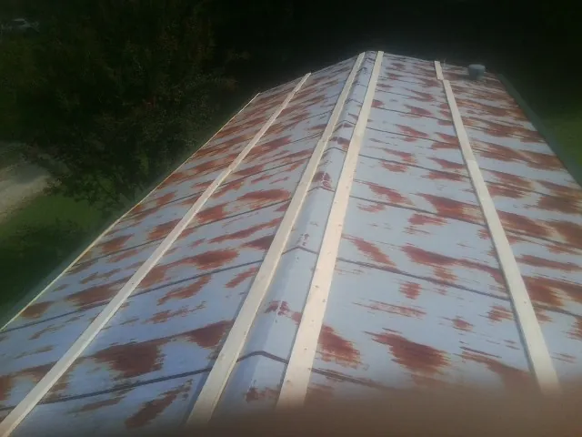 Rusted metal roof panels with new wood purlins before replacement — Storm Damage Roof Repair in Phillips by Roofing Brothers