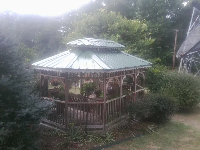 Green metal roof on a backyard gazebo surrounded by garden beds in Phillips